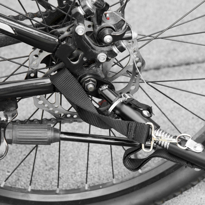 Close-up of a bicycle wheel with a strap and lock attached, on a pavement background.